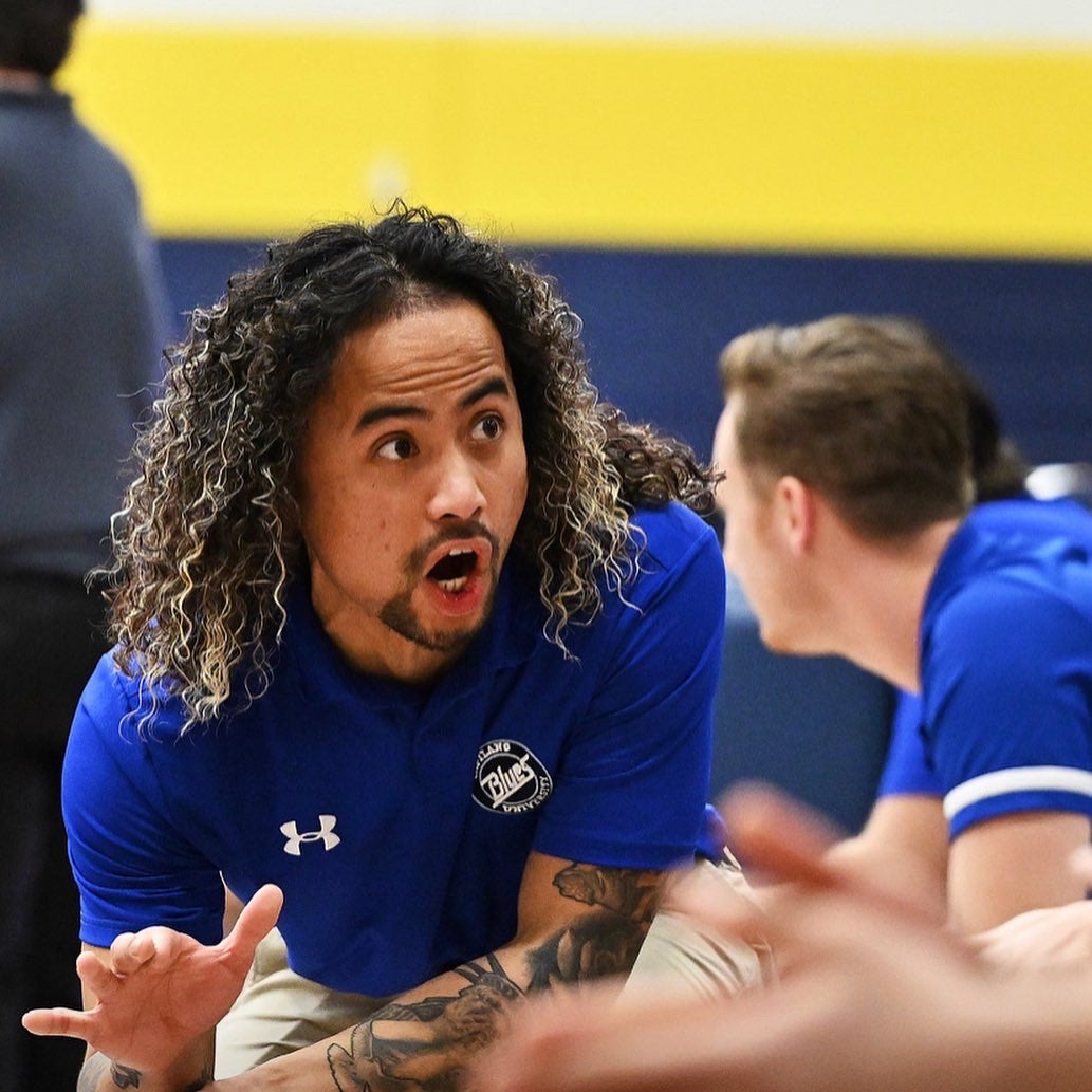 coach ivy talking to a player about basketball in an indoor court locateted in vancouver